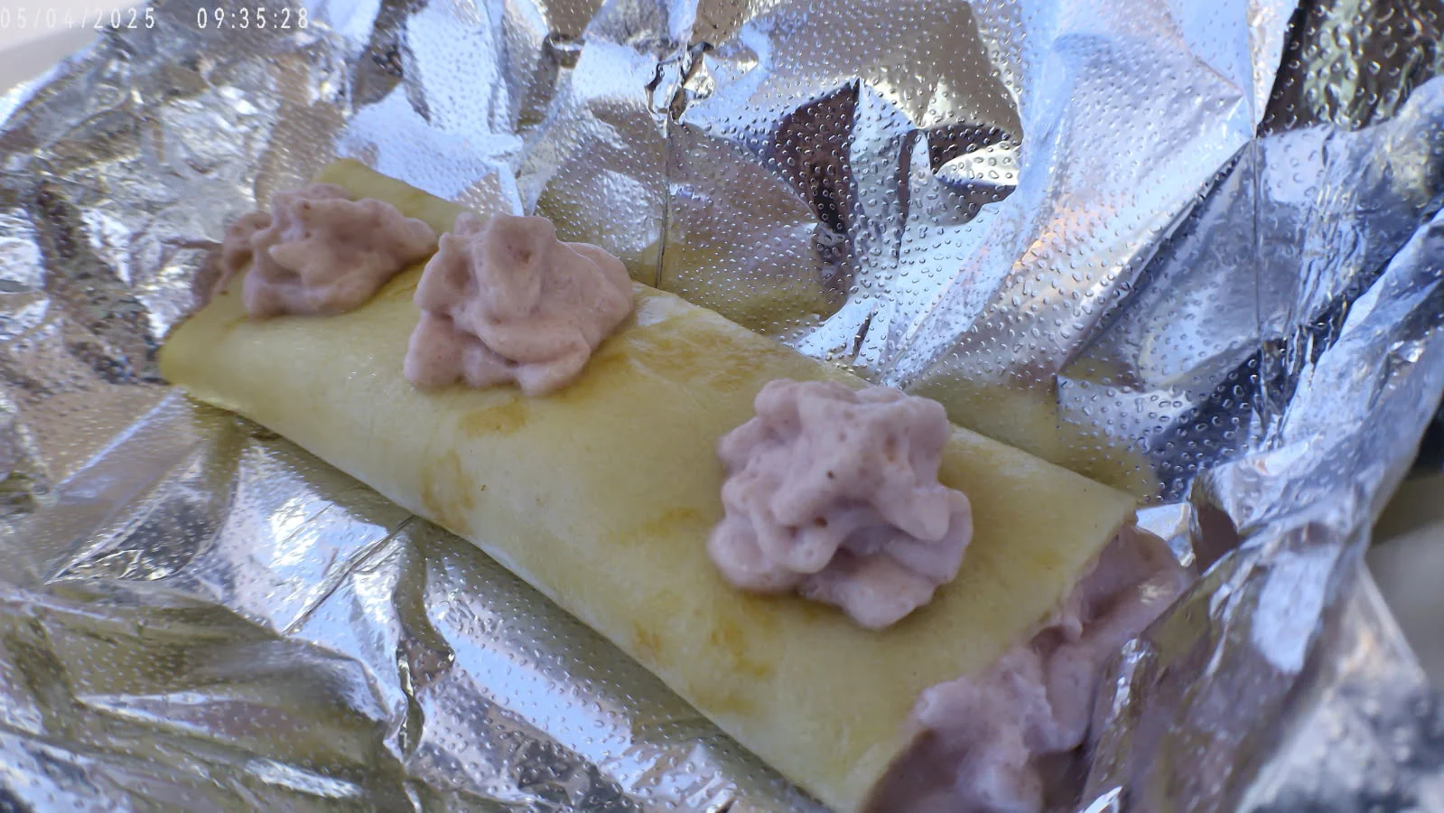 Mexican sweet crepe topped with whipped cream in foil