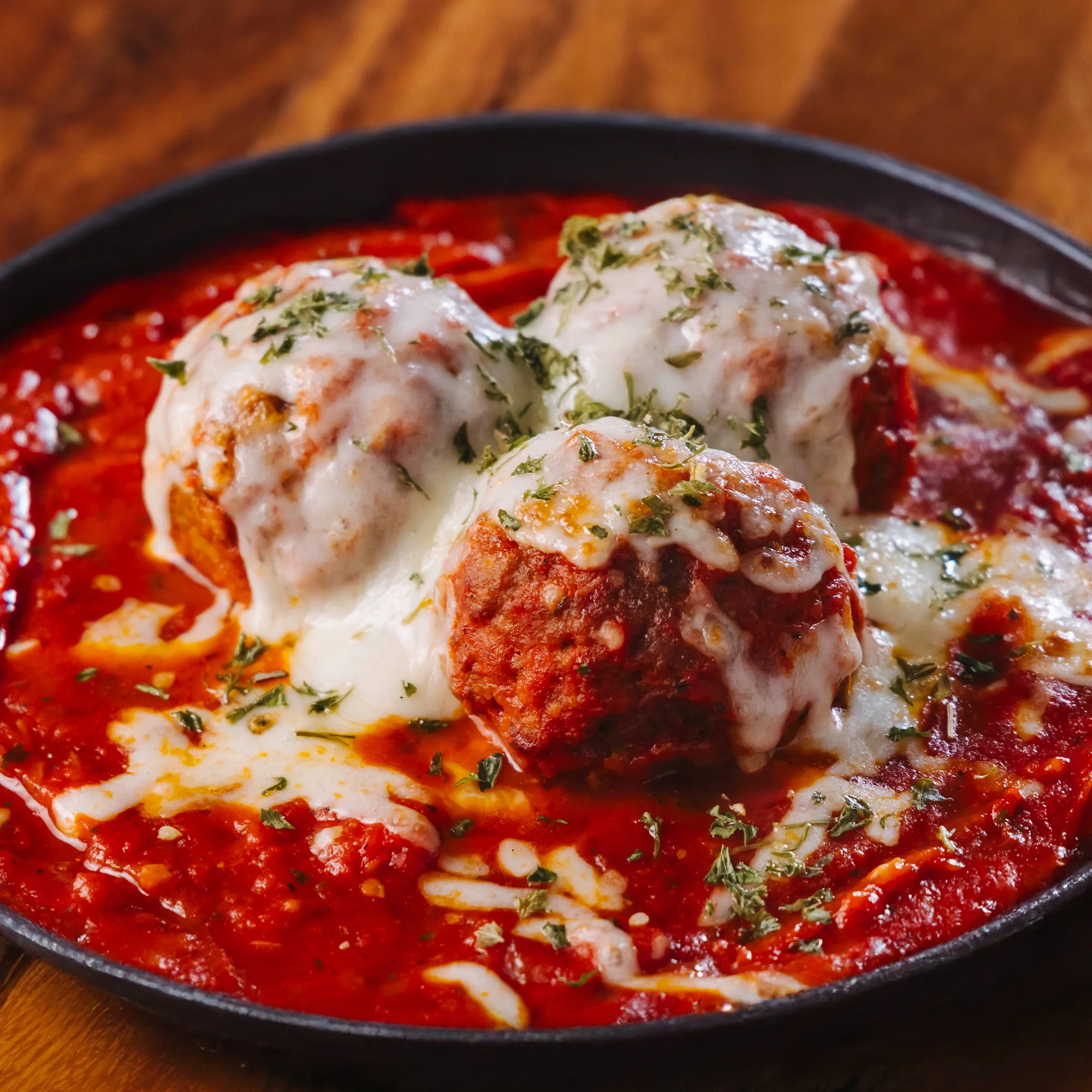 Italian meatballs in marinara sauce topped with melted cheese