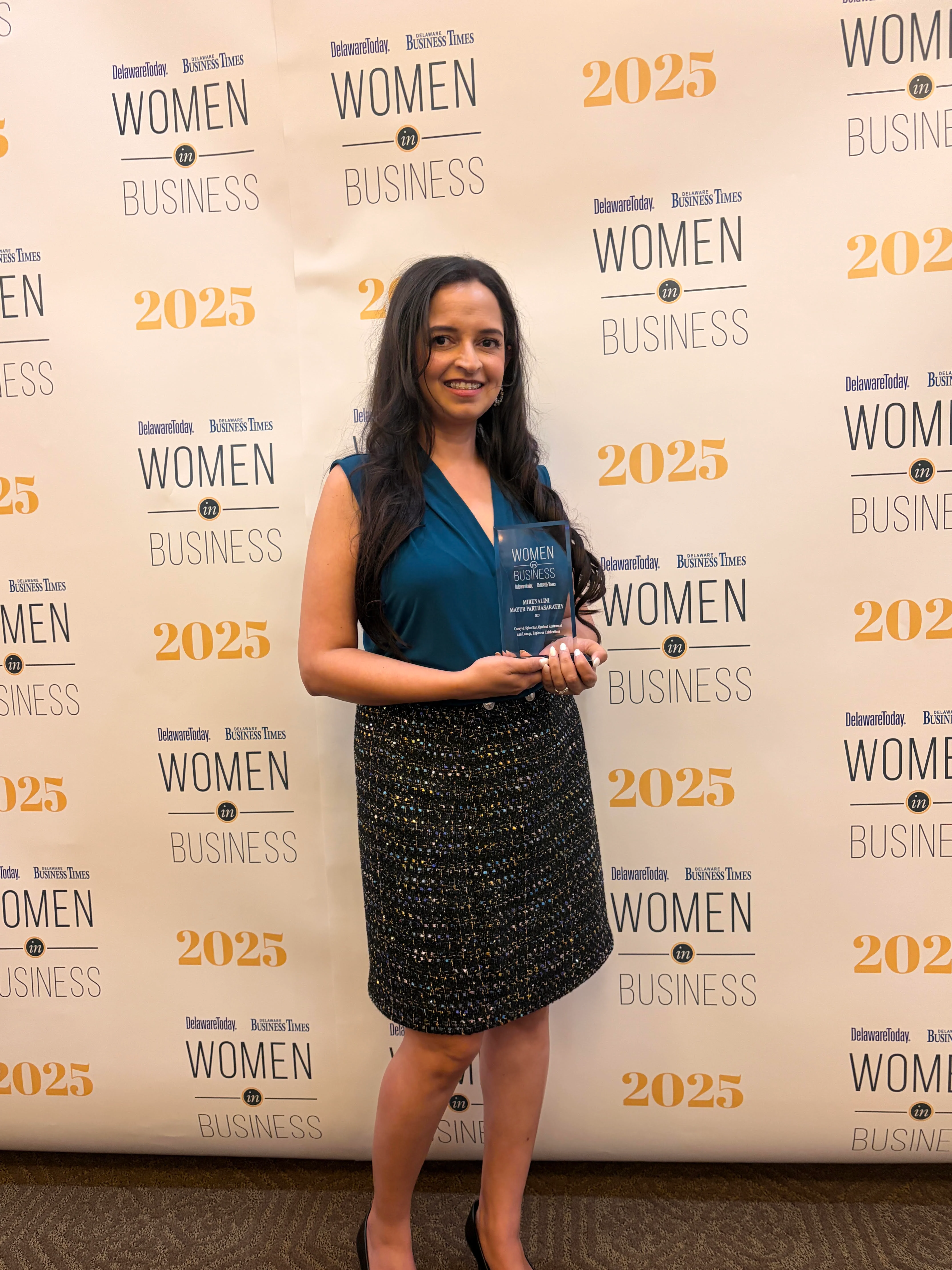 Restaurant professional posing at a Delaware business awards event backdrop