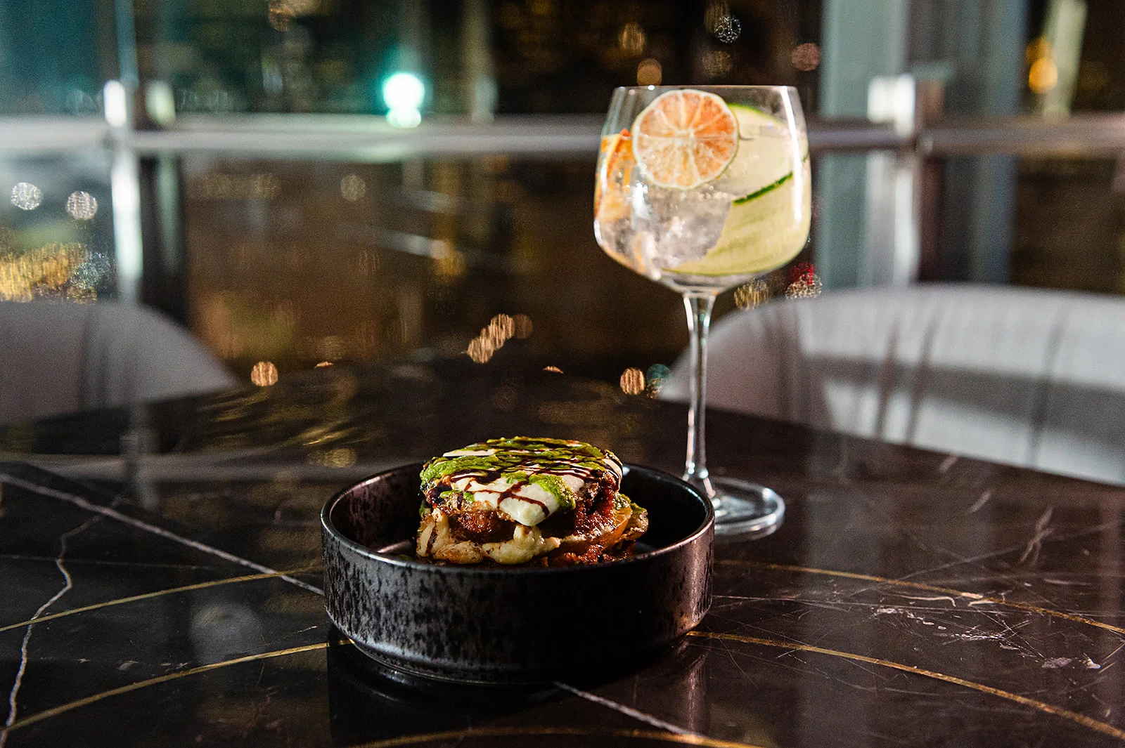 Gourmet Mexican torta with cocktail in upscale restaurant