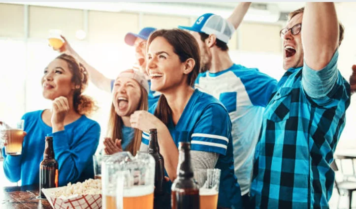 Group of friends celebrating with drinks at a sports bar