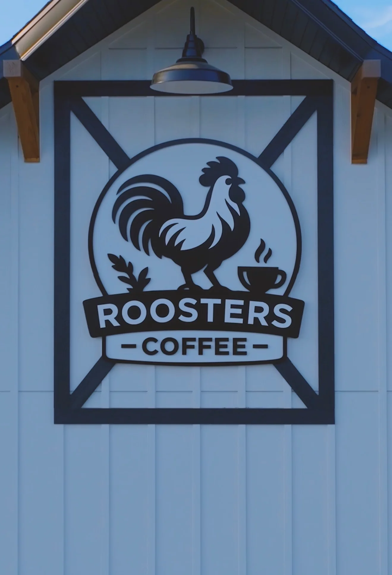Roosters Coffee logo on a rustic barn-style café exterior