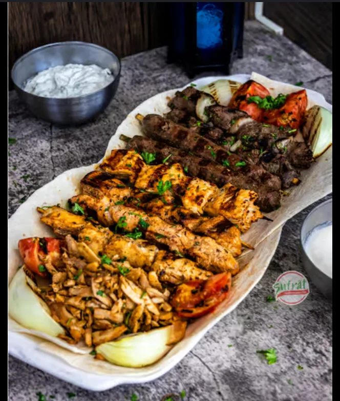 Mixed grill platter featuring kebabs and chicken shawarma