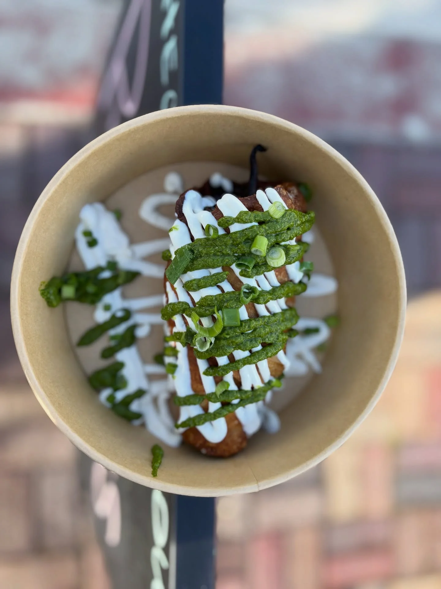 Stuffed Mexican chile relleno with green sauce and crema