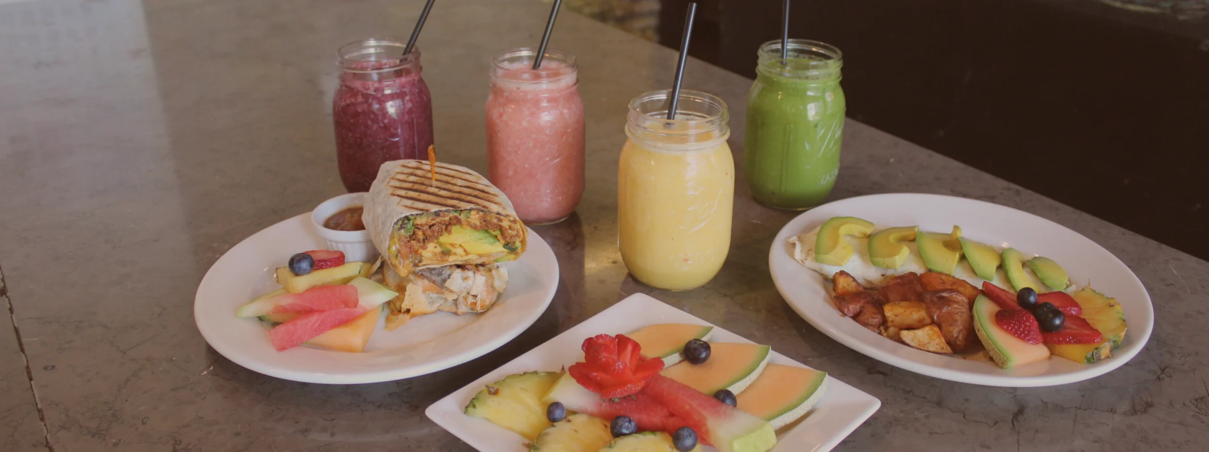 Colorful smoothie bowls and fresh fruit platters in a vibrant café setting