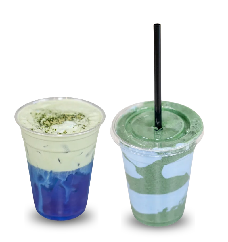 Colorful assortment of smoothies in clear cups with fresh fruit garnishes.