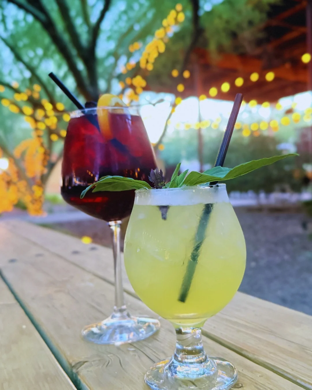 Colorful cocktails served outdoors with string lights