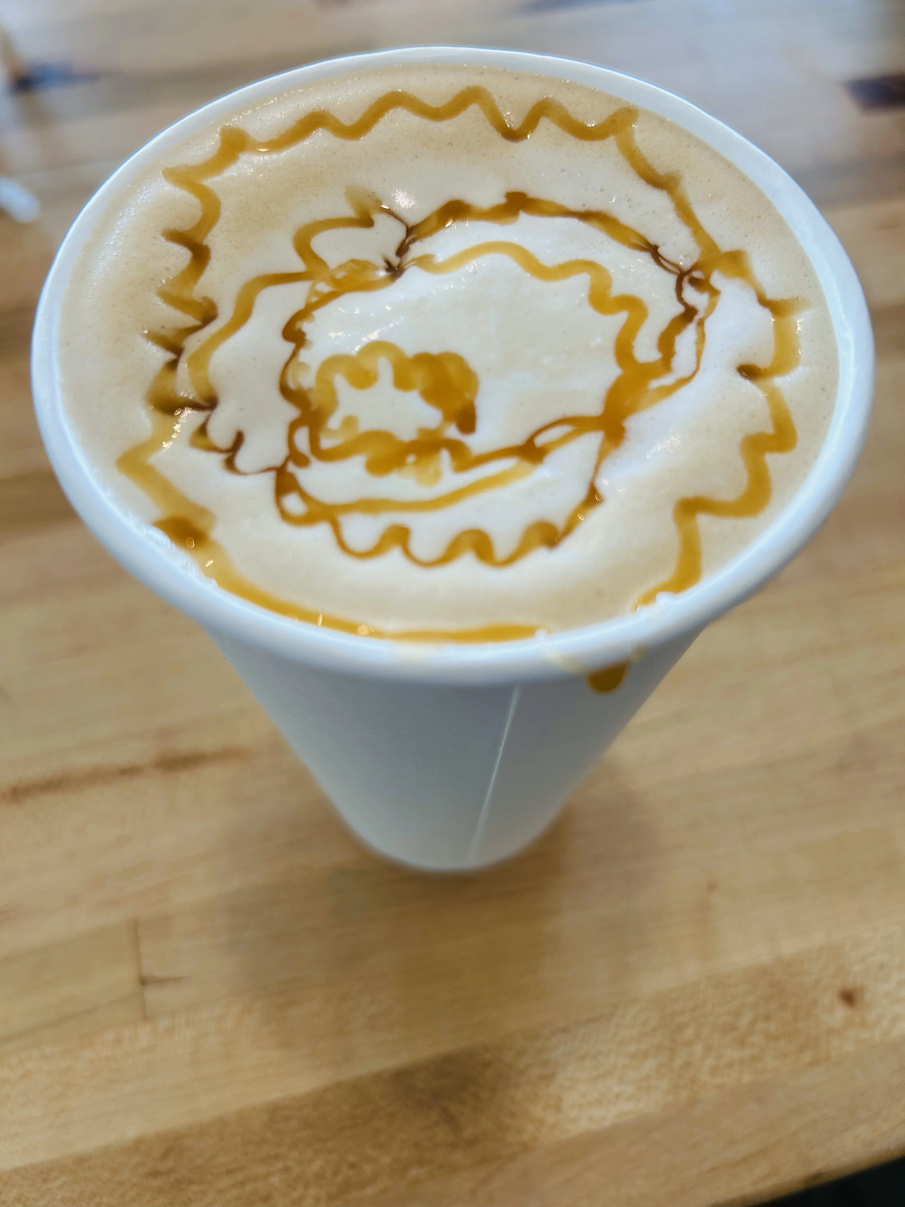 Caramel latte art in a white cup