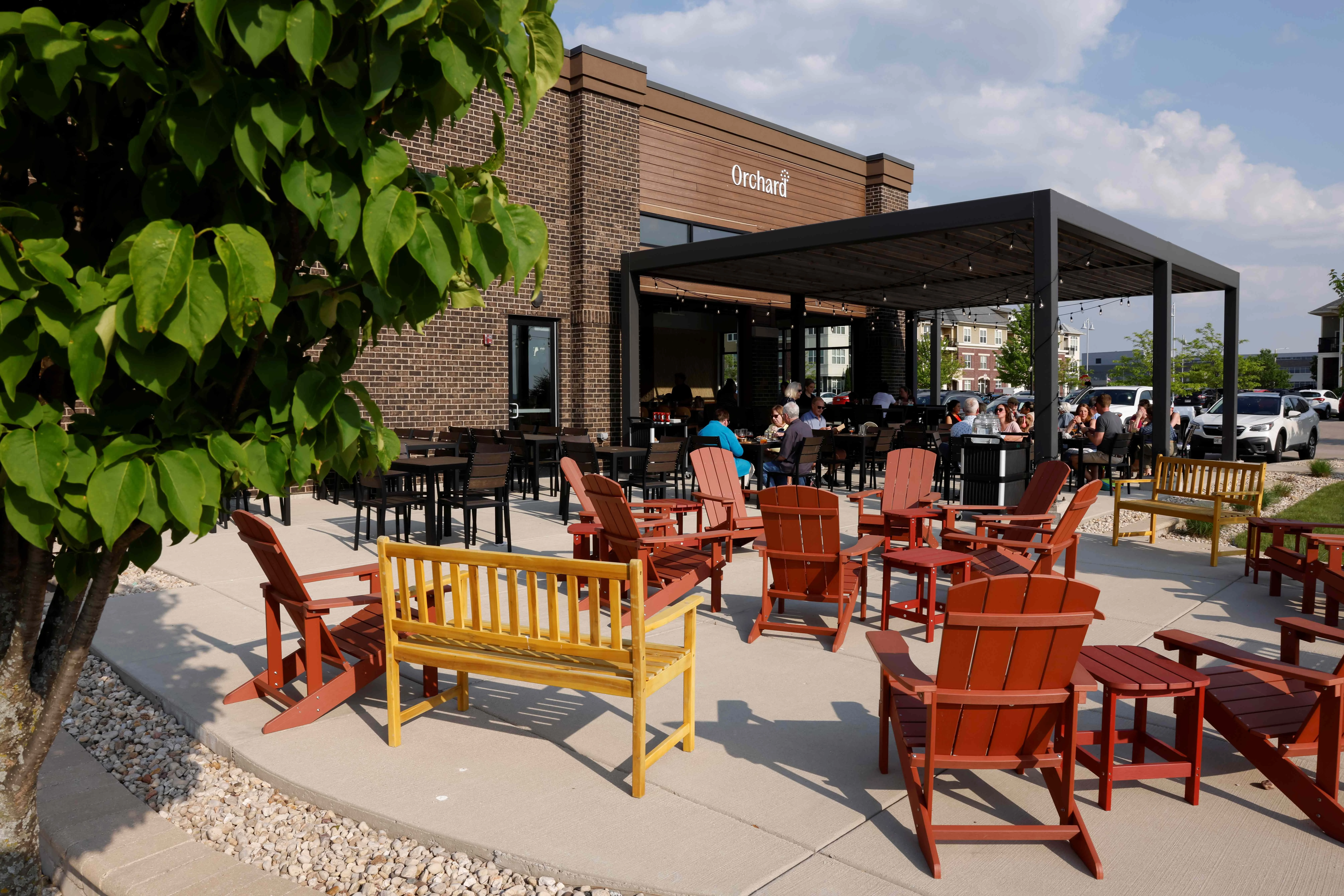 Outdoor dining area with colorful chairs and a modern restaurant facade