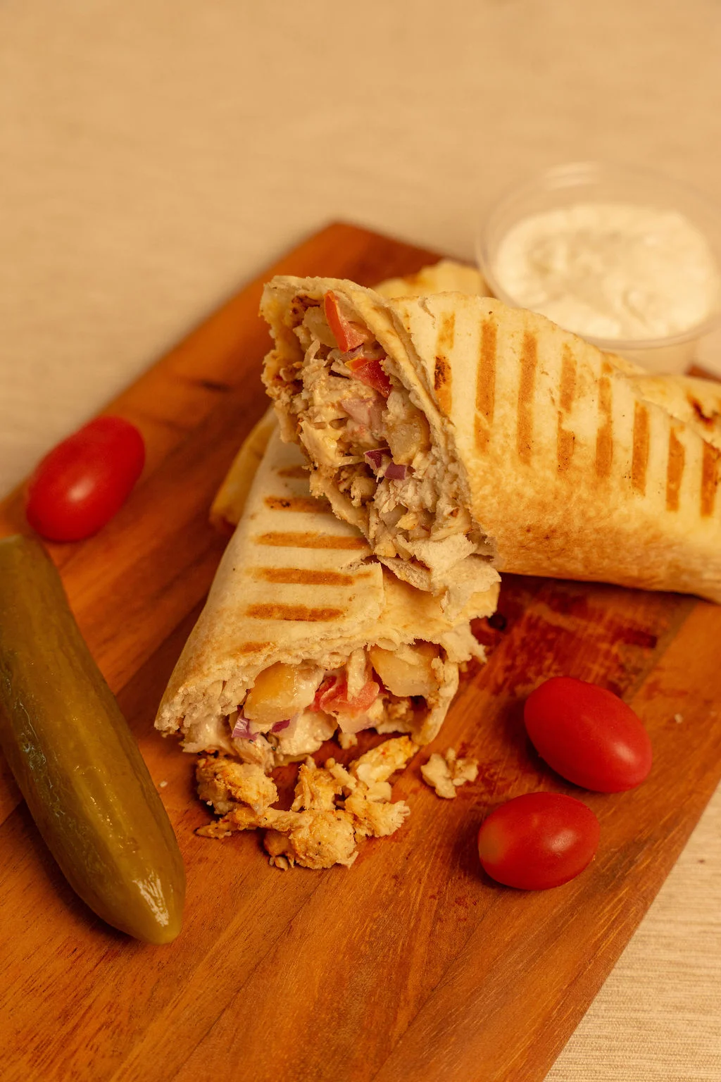Grilled chicken wrap with fresh vegetables, served with pickles and sauce
