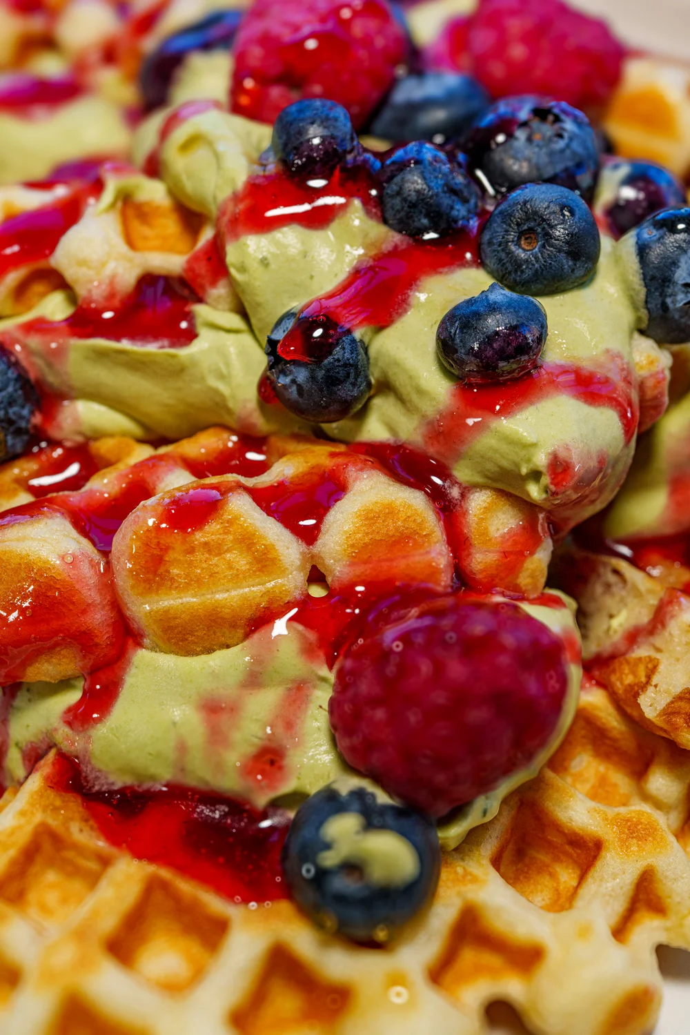 Belgian waffles topped with matcha ice cream and mixed berries
