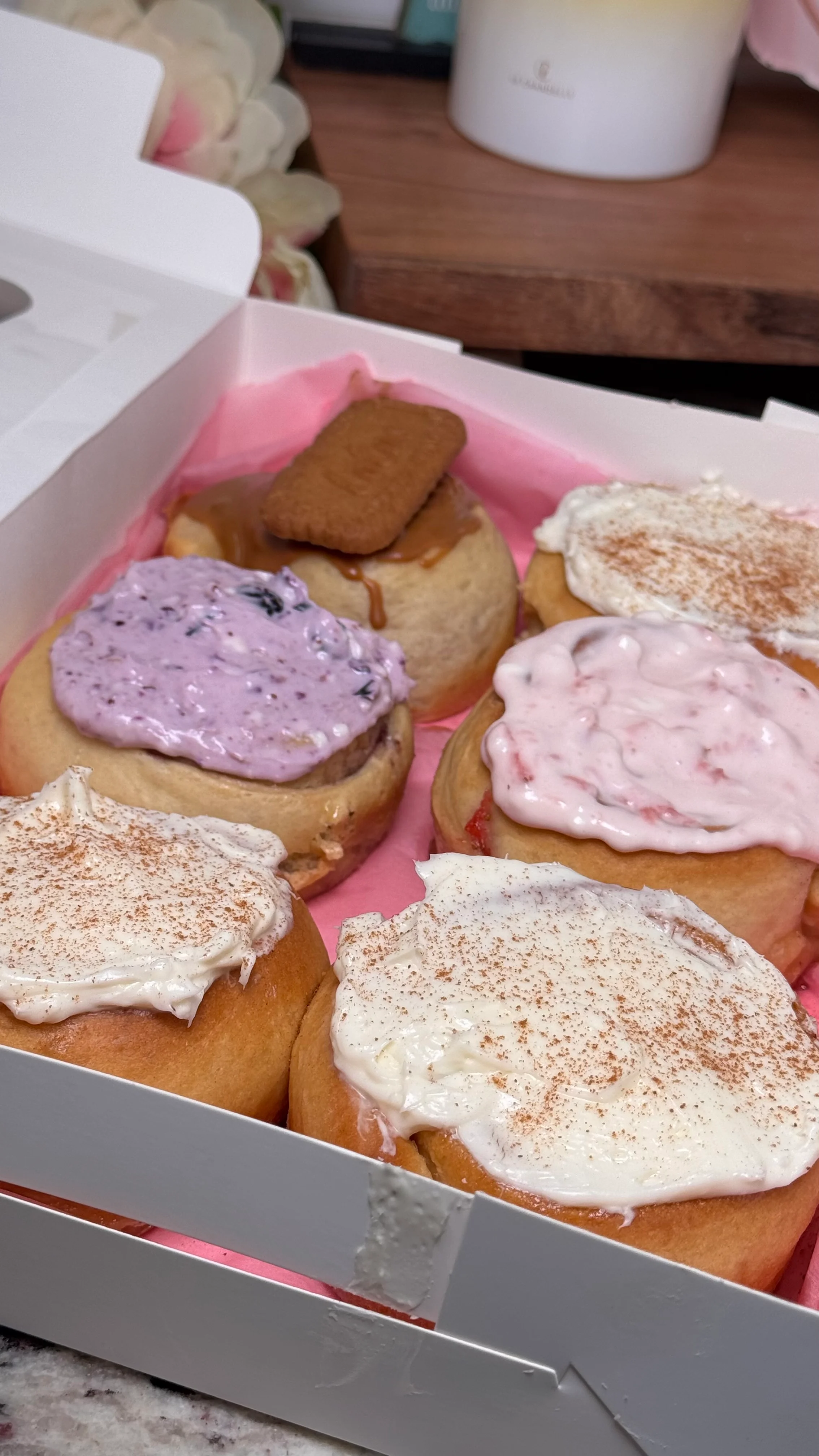 Assorted gourmet cinnamon rolls with colorful frostings and toppings