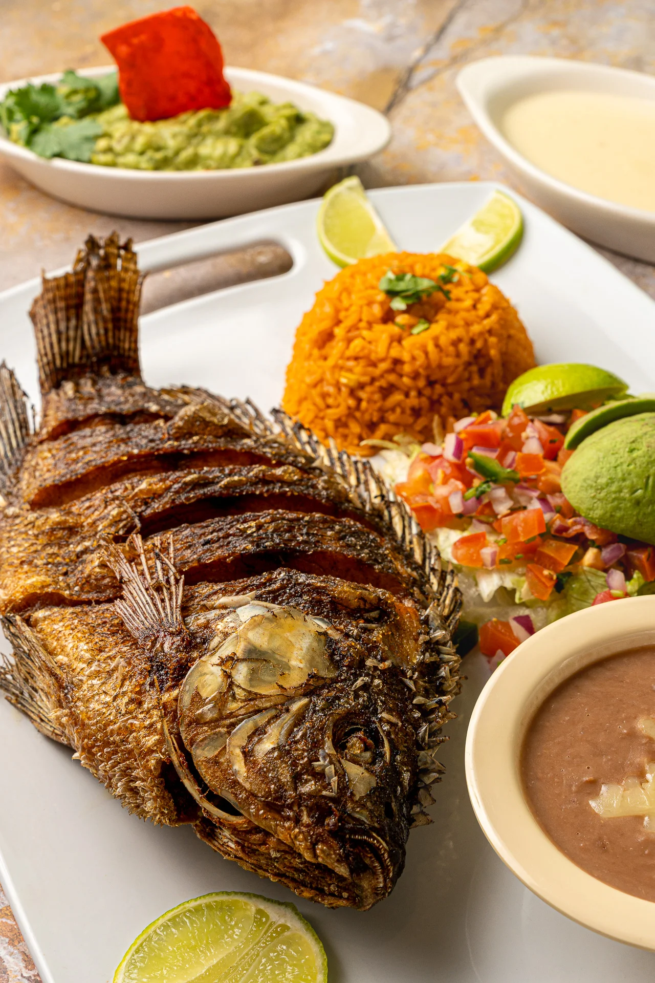 Whole fried fish served with Mexican rice and guacamole