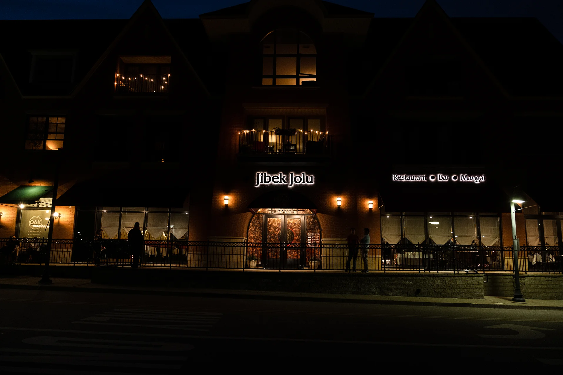 Exterior view of Jibek Jolu restaurant at night with warm lighting
