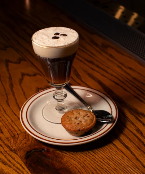 A delicious Irish coffee topped with whipped cream in a glass mug.