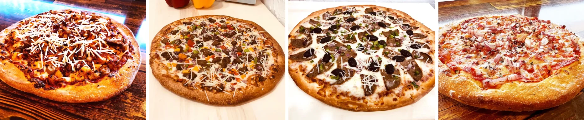 Assorted gourmet pizzas on wooden table