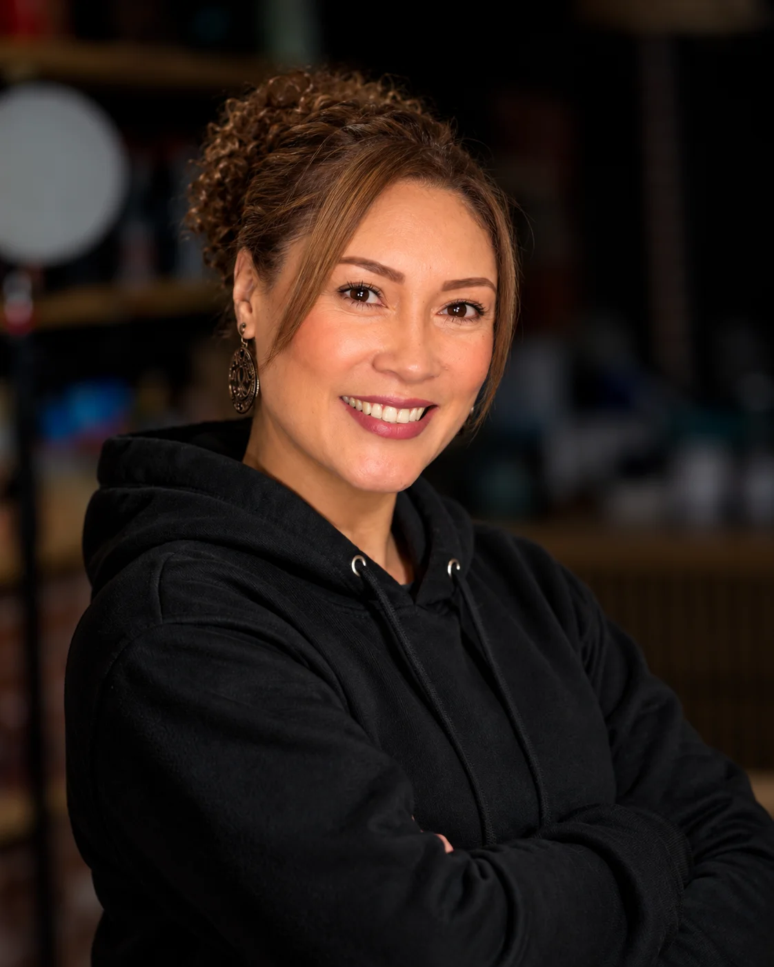 Professional portrait of smiling restaurant staff member in a dining room