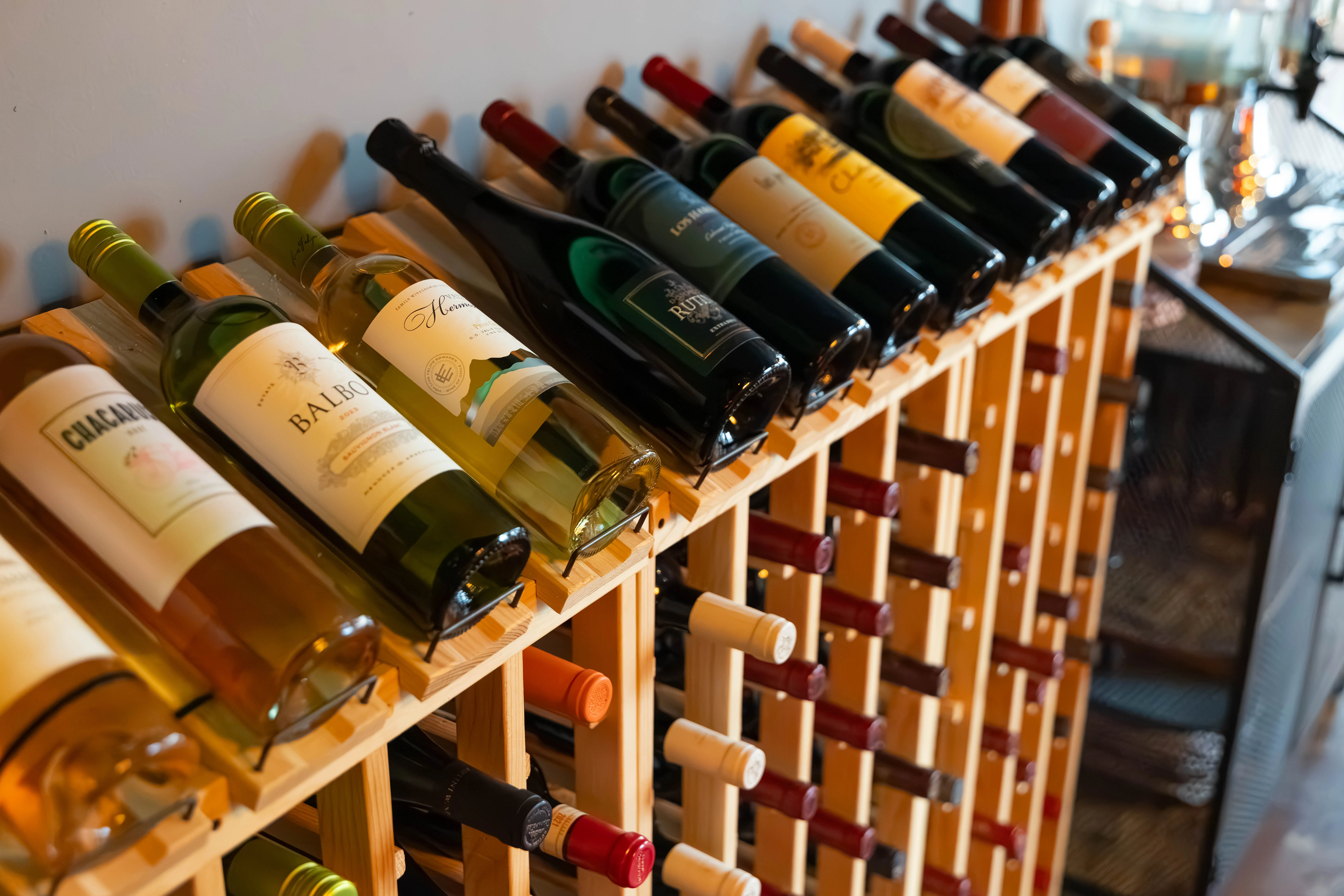 Wine bottles displayed on a wooden rack in a cozy restaurant