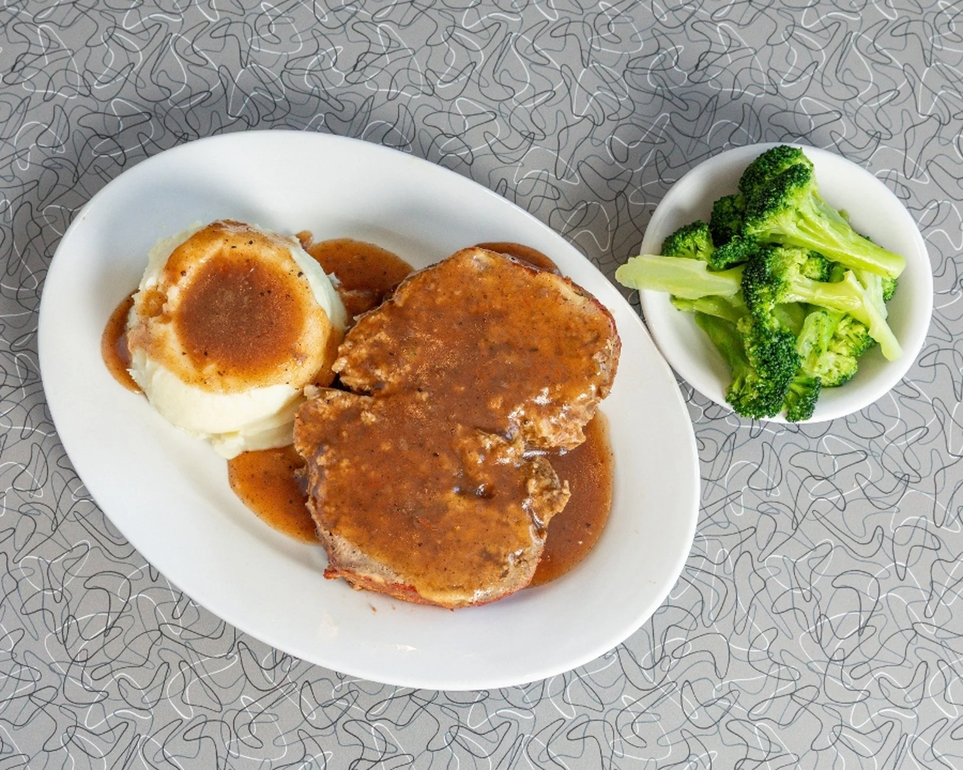 Country fried steak with gravy, mashed potatoes, and steamed broccoli