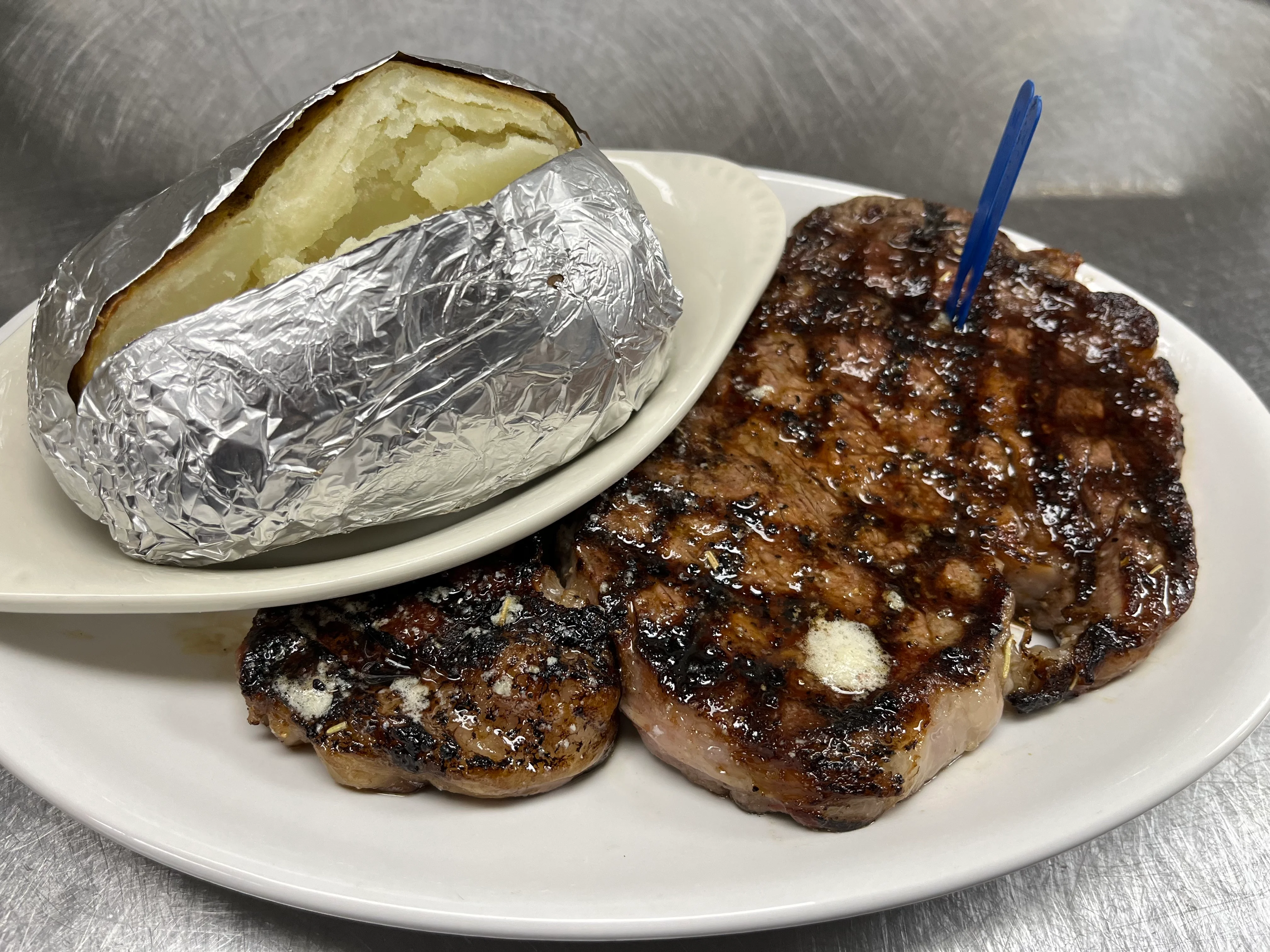 Grilled steak with baked potato, classic American dish