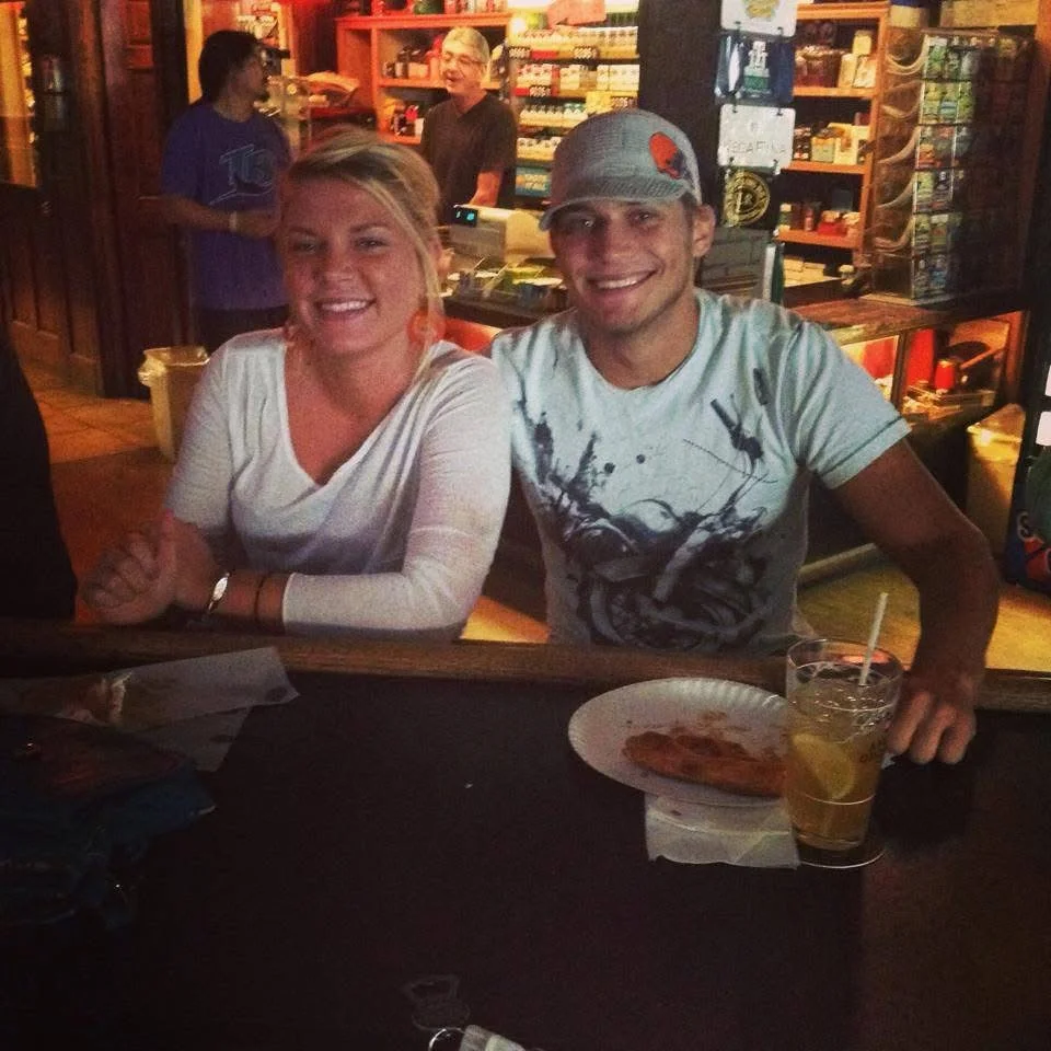 Bartender smiling while serving drinks at a lively bar