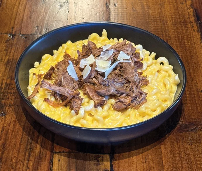 Creamy mac and cheese topped with pulled beef