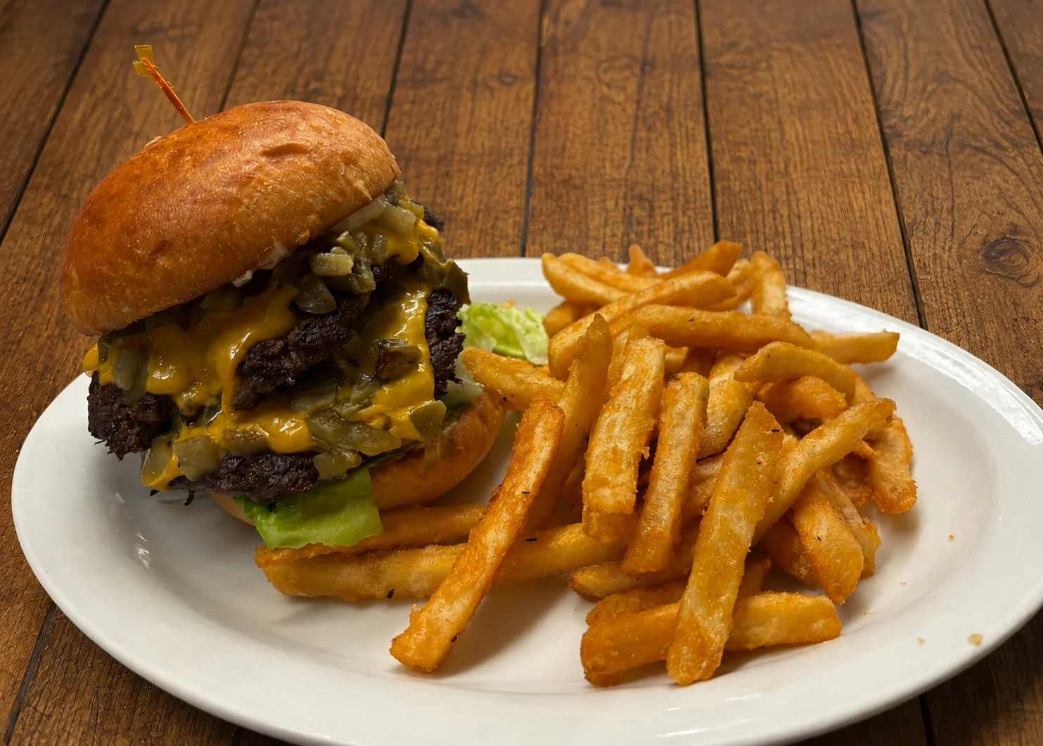 Juicy cheeseburger with fries on a wooden table