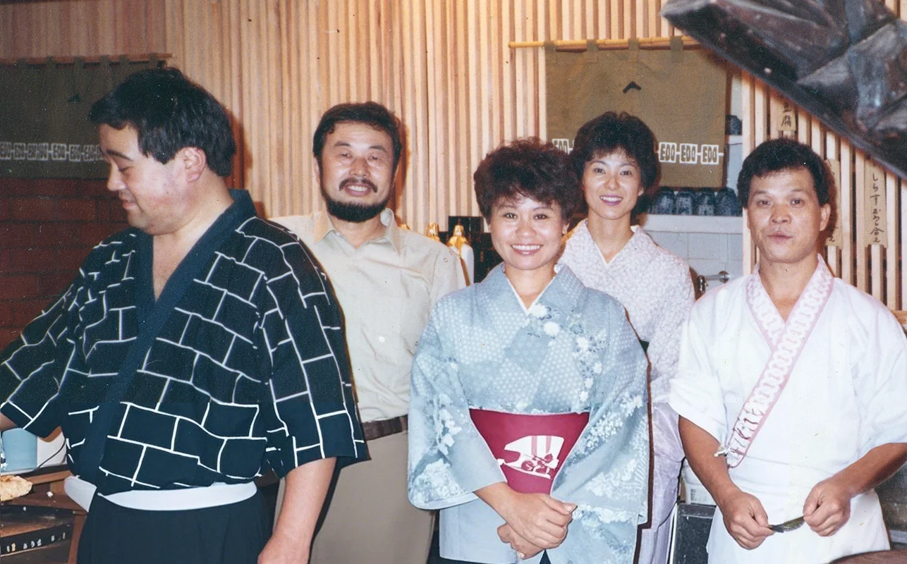 Group of chefs in traditional Japanese attire at a restaurant