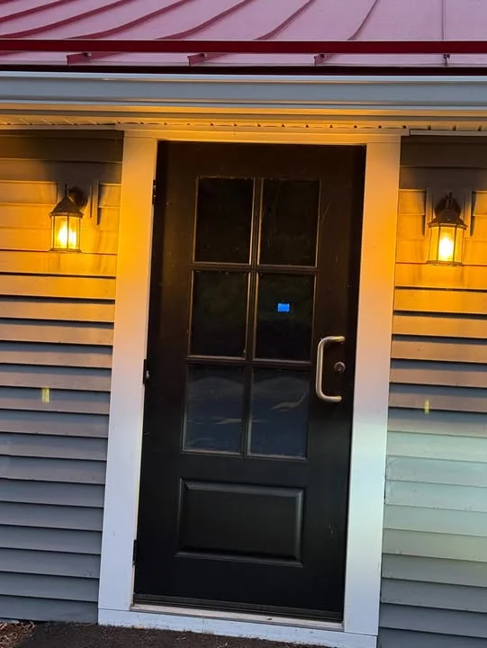 Charming entrance with black door and warm outdoor lighting