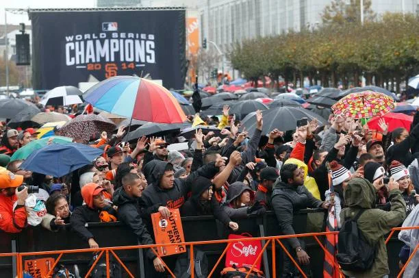 Crowd celebrating World Series victory with umbrellas in San Francisco