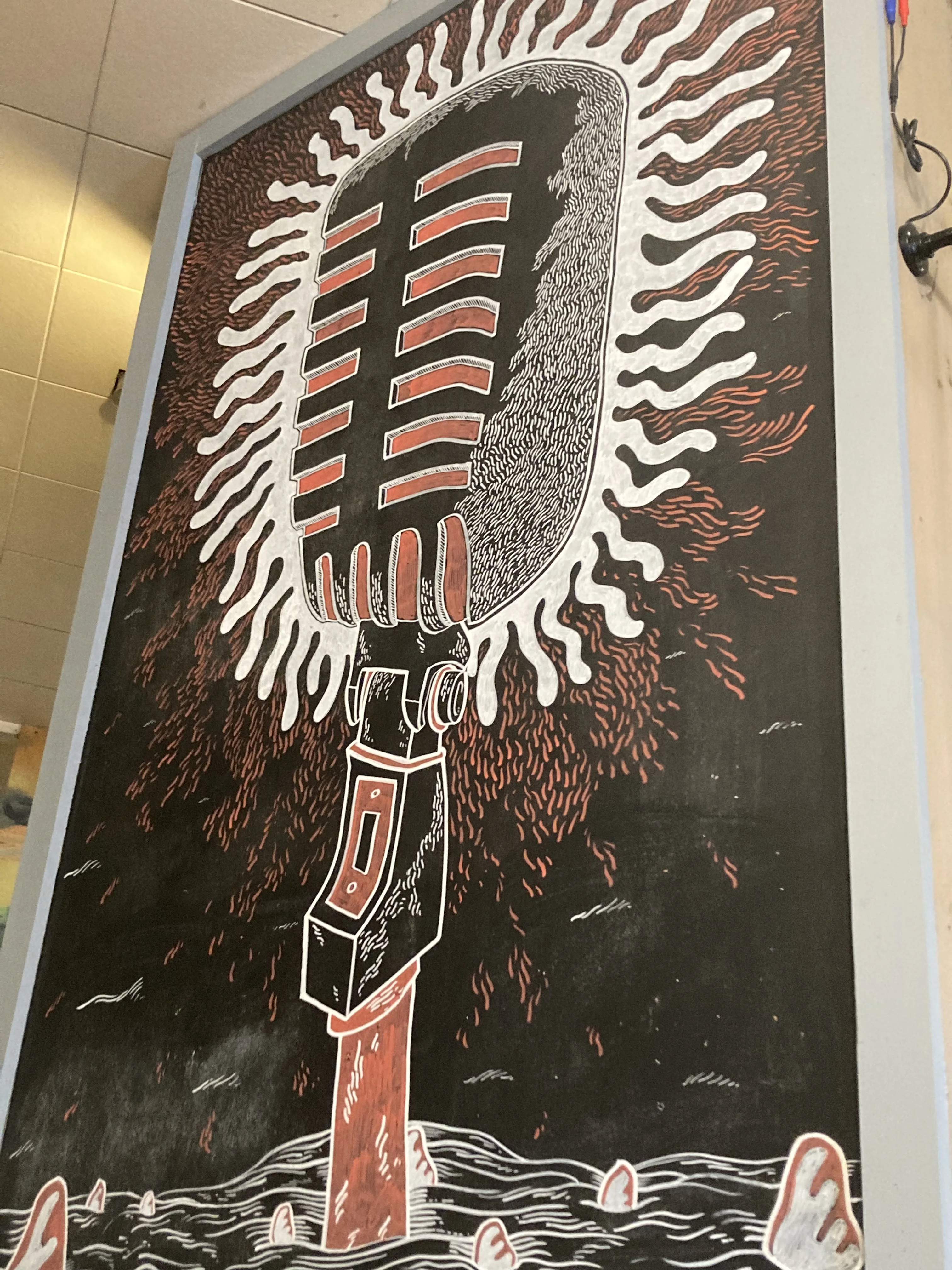 Artistic mural of a vintage microphone with sunburst design
