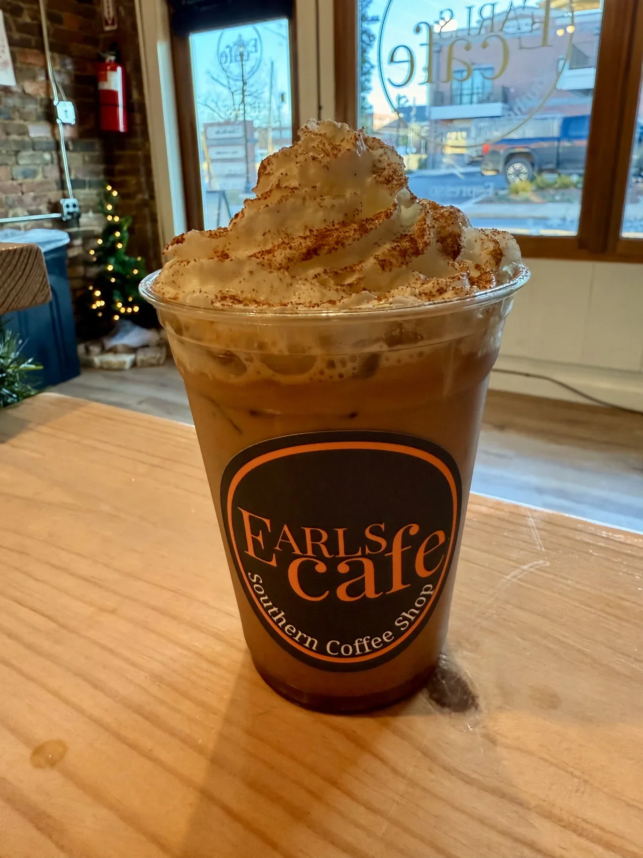Iced coffee topped with whipped cream and cinnamon