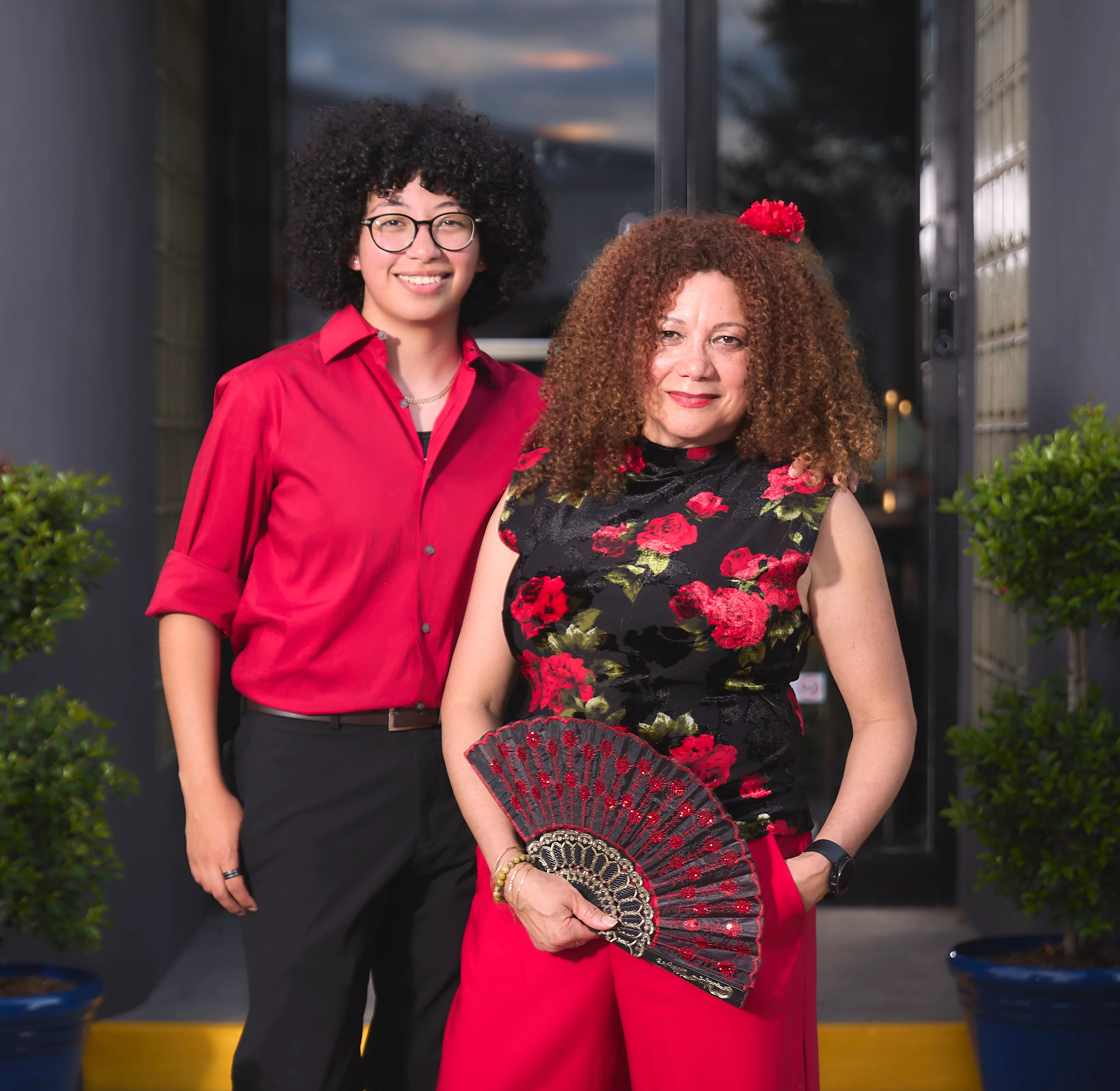 Two restaurant staff members posing outside a vibrant eatery entrance