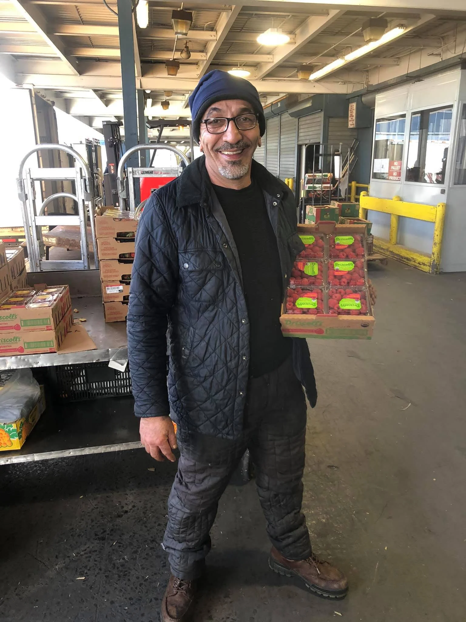 Man holding fresh strawberries in a market