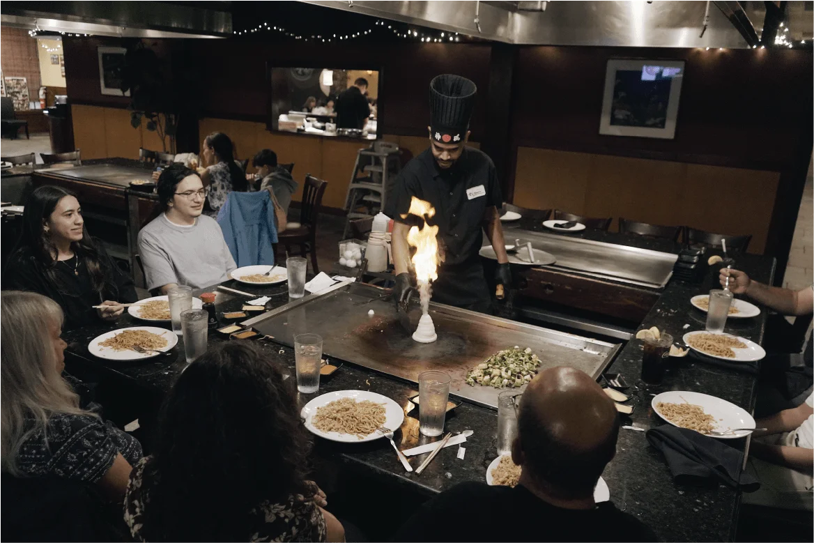 Hibachi chef lighting the onion volcano for a full table of guests at Mahzu East Windsor, NJ