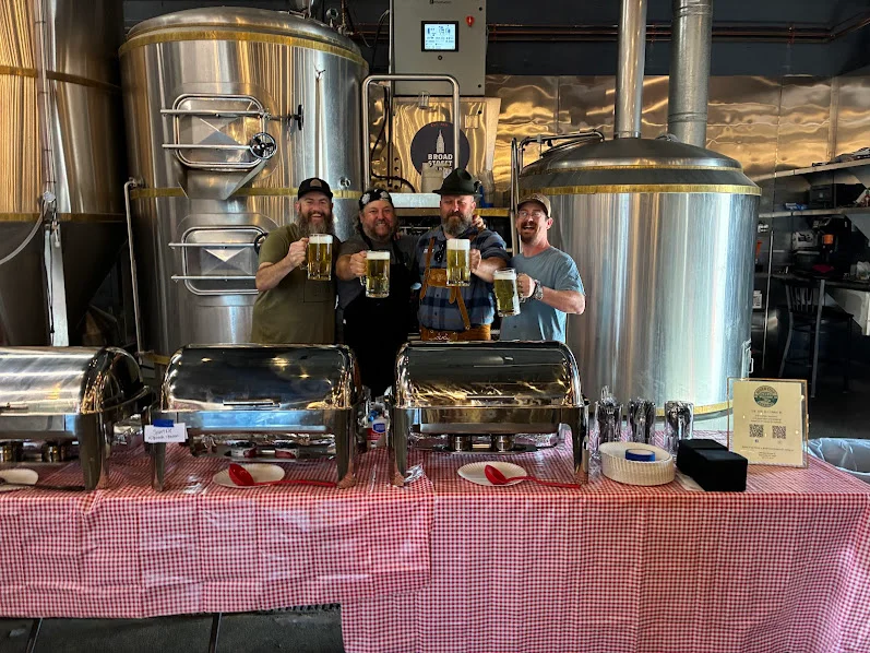 Group of friends celebrating with beer at a brewery
