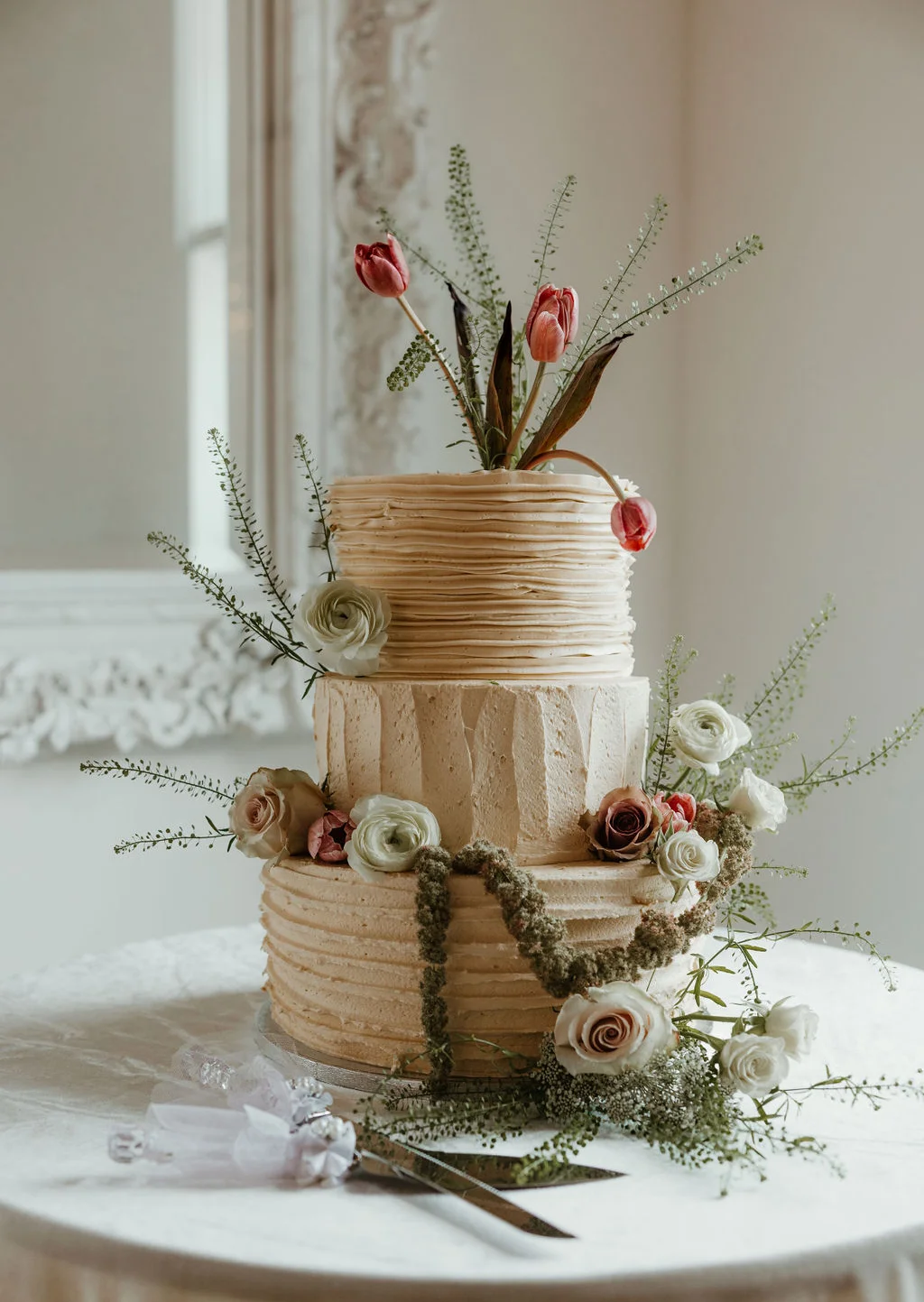 Elegant three-tier wedding cake adorned with fresh flowers