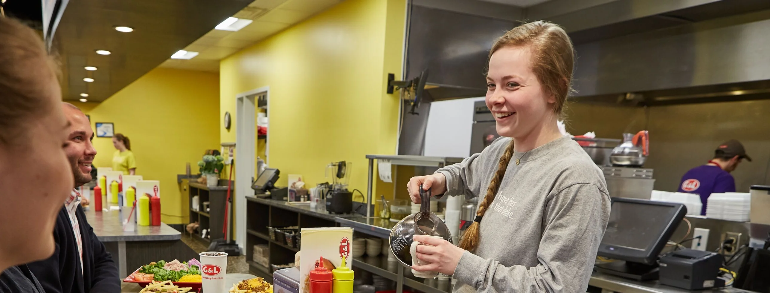 Friendly server pouring drinks in a casual diner setting
