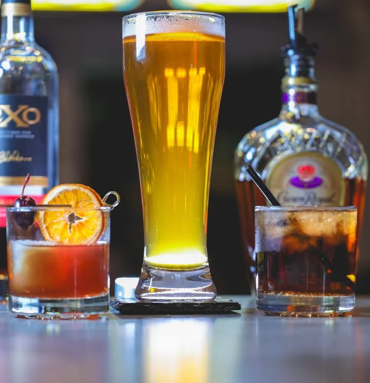 Assorted cocktails and beer on a bar counter