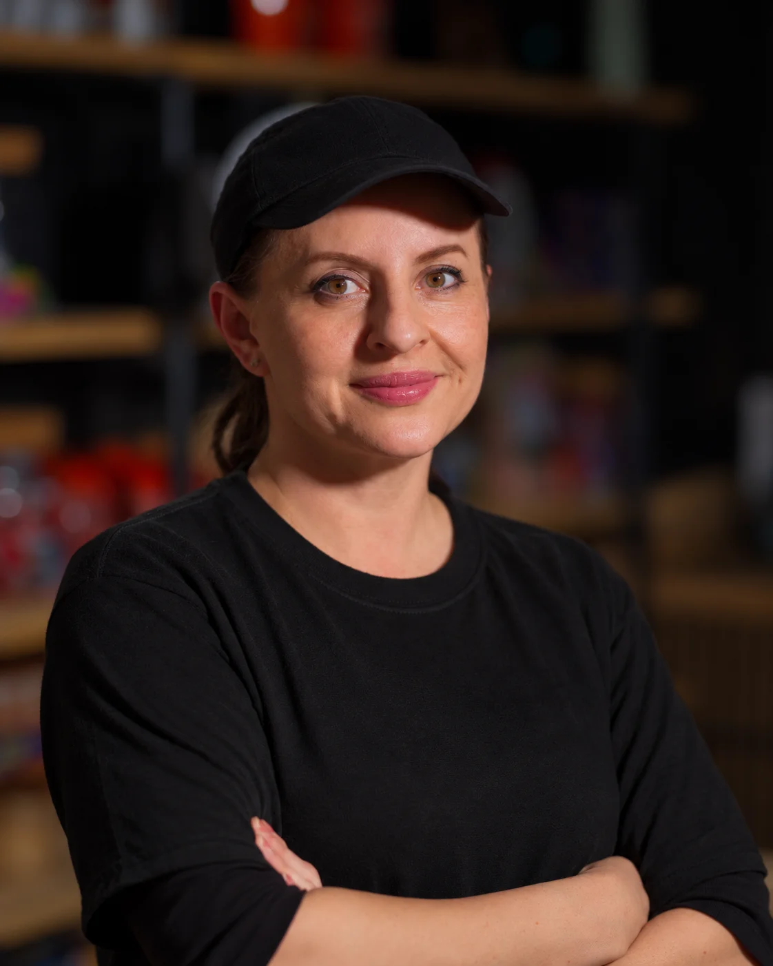 Professional portrait of a restaurant staff member in a black cap and shirt