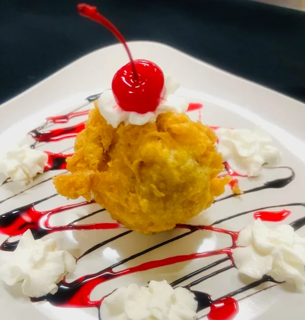 Deep-fried ice cream dessert with cherry on top