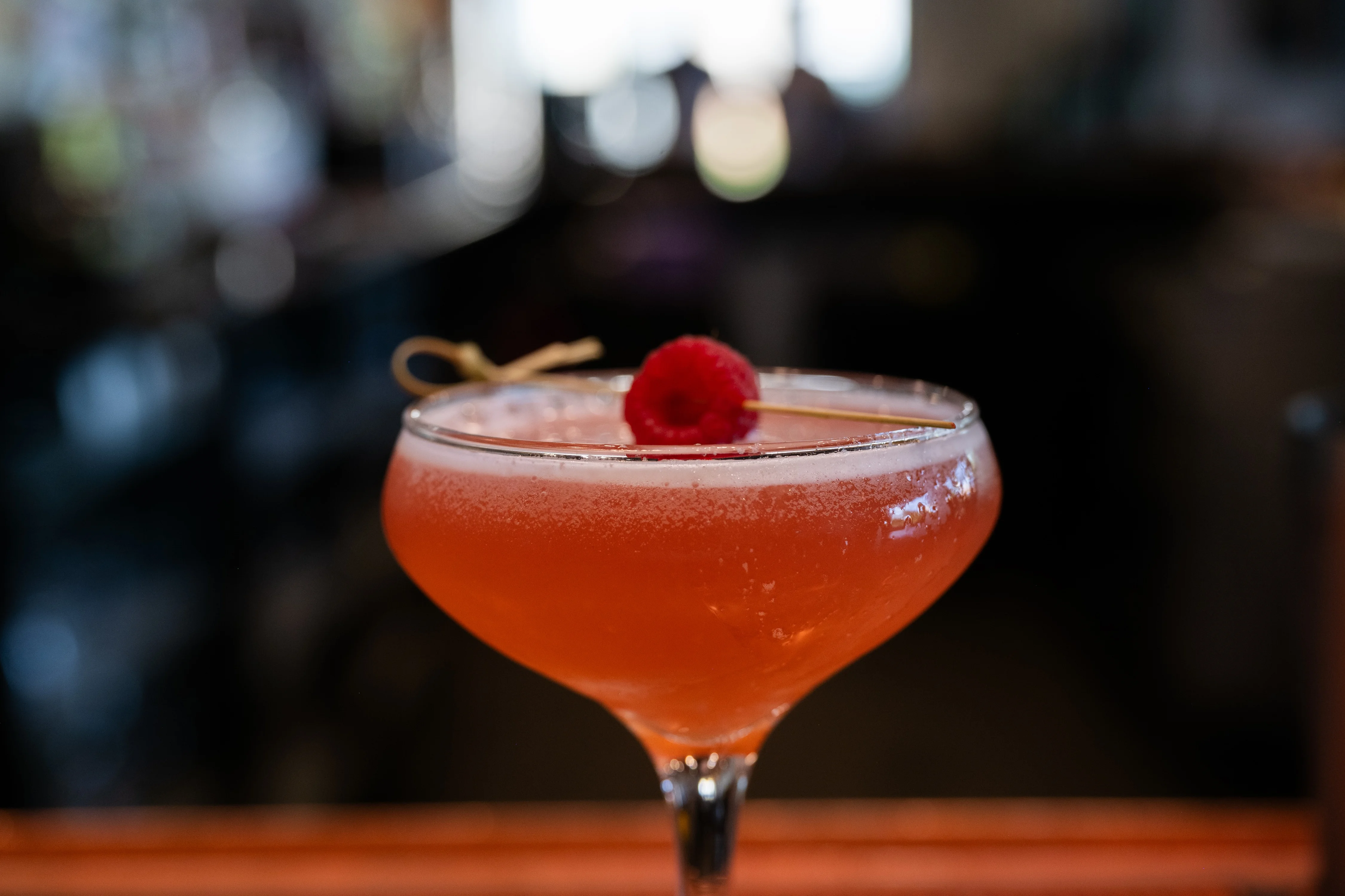 Refreshing cocktail garnished with raspberry in a stylish glass