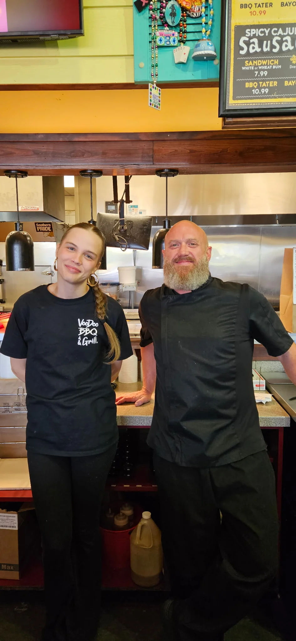VooDoo BBQ Pensacola team members in the kitchen, highlighting a friendly work environment and local job opportunities.