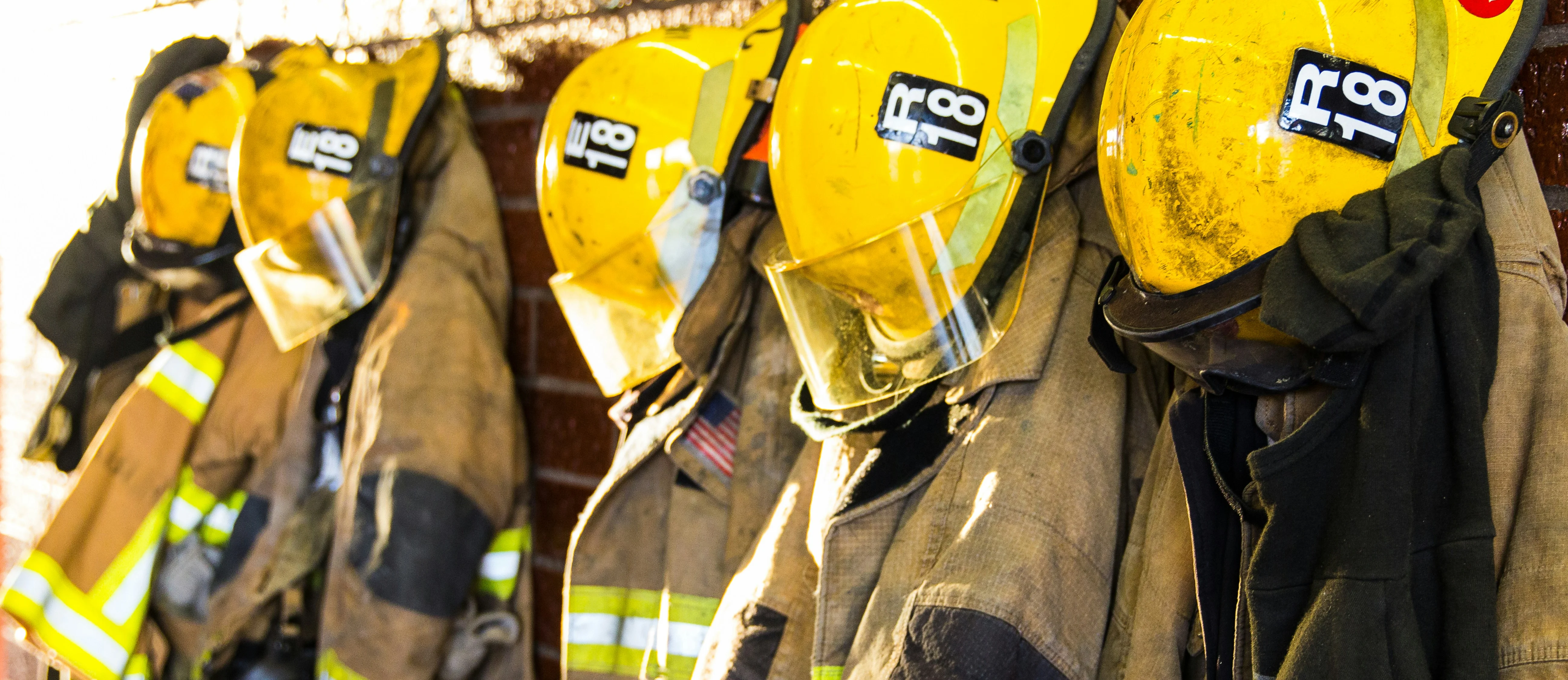 Firefighter gear hanging on a wall in a fire station