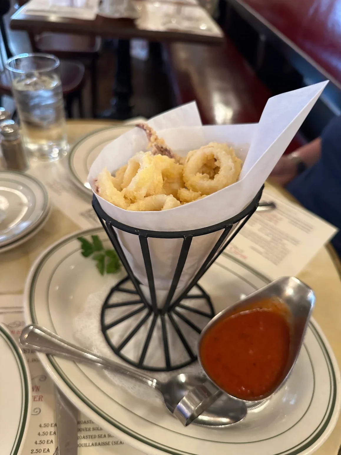 Crispy calamari served with marinara sauce in a restaurant setting