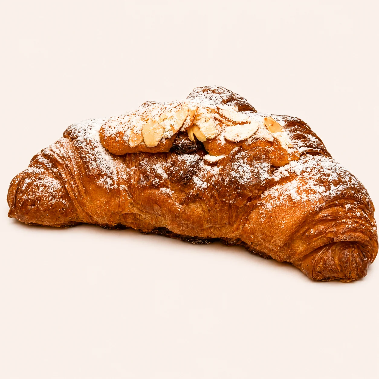 An almond croissant dusted with powdered sugar, featuring a flaky and buttery exterior.