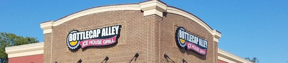 A close-up view of the restaurant's sign with the name clearly visible against the brick facade.