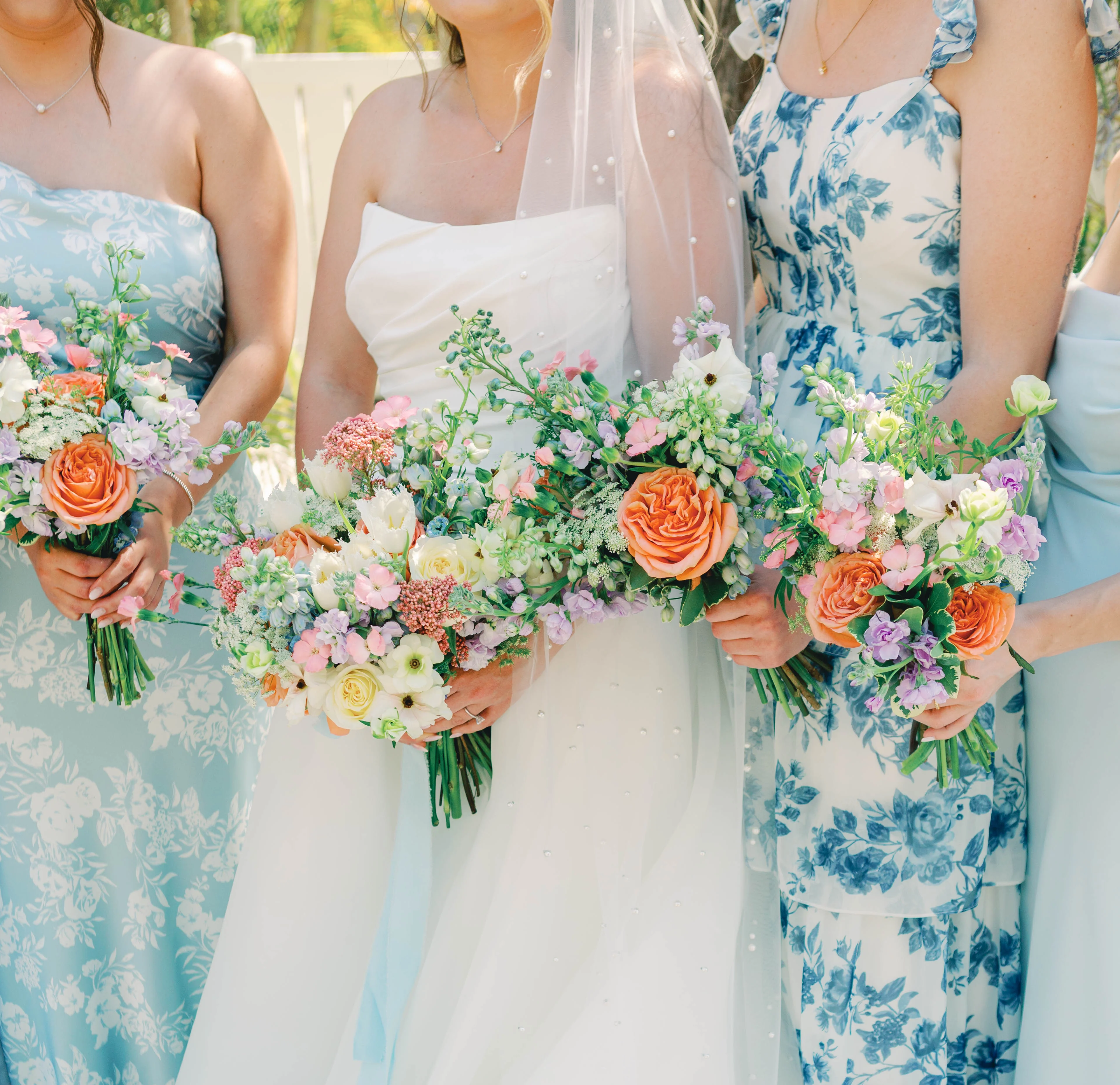 Bridesmaids holding colorful floral bouquets at a wedding