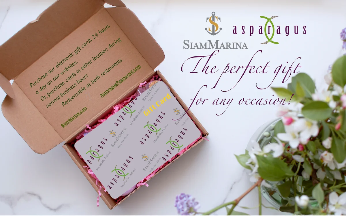 Photo of our gift card in an open gift box with flowers on the table to the right