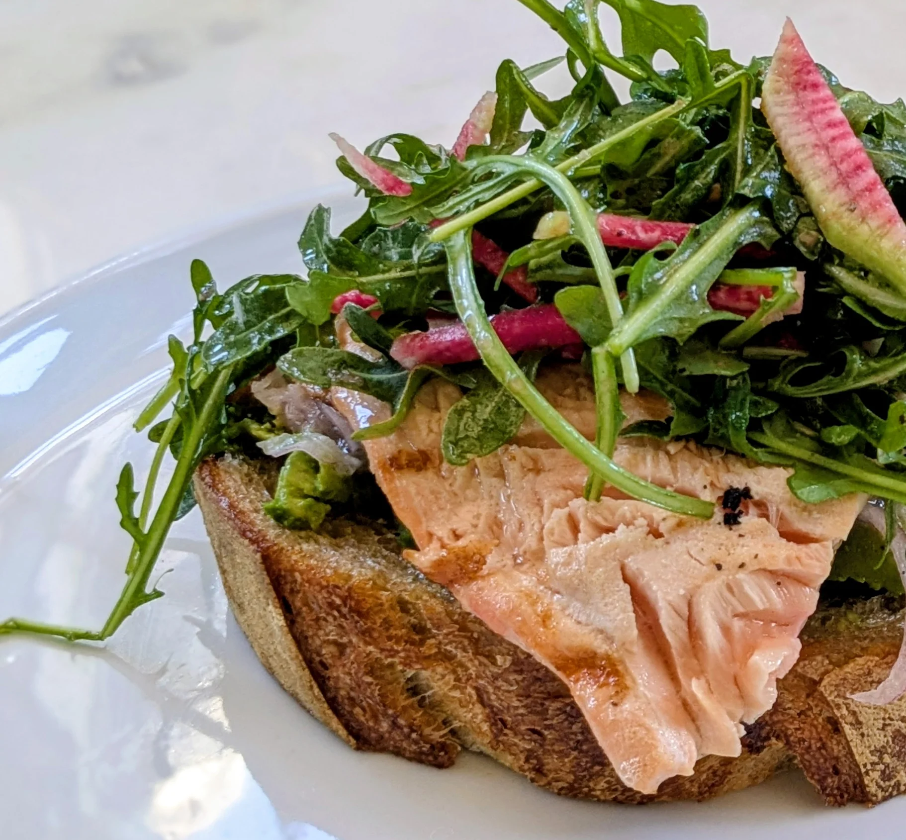 Open-faced salmon tartine with arugula salad